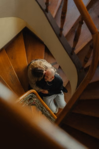 Couple embracing on a wooden spiral staircase, viewed from above