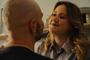 Close-up of a couple smiling at each other indoors, warm light
